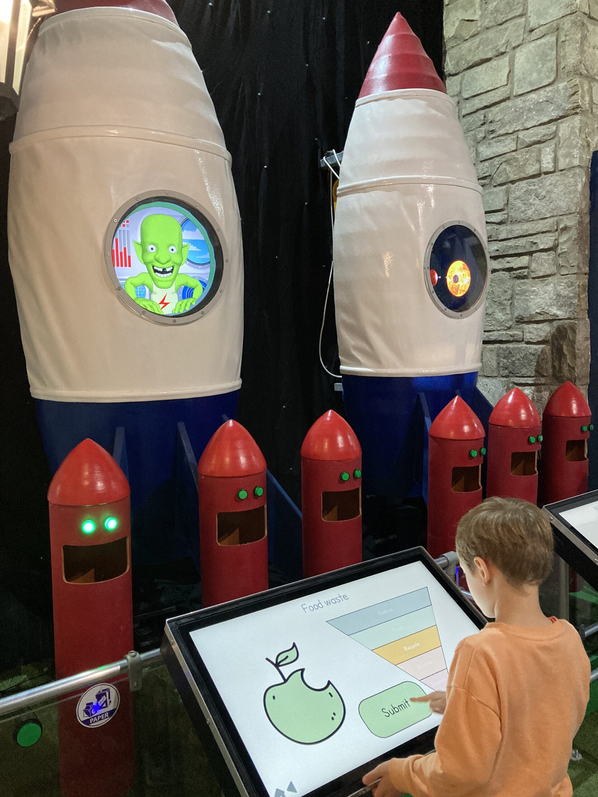 Child playing interactive recylcling rocket game